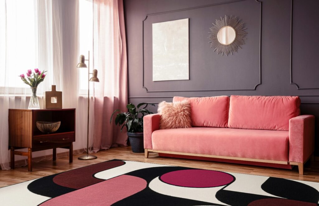 Kolorowy dywan w stylu art déco z dużymi polami różu, bordo, czerni i bieli w salonie, dostępny w ofercie Dywany Witek.